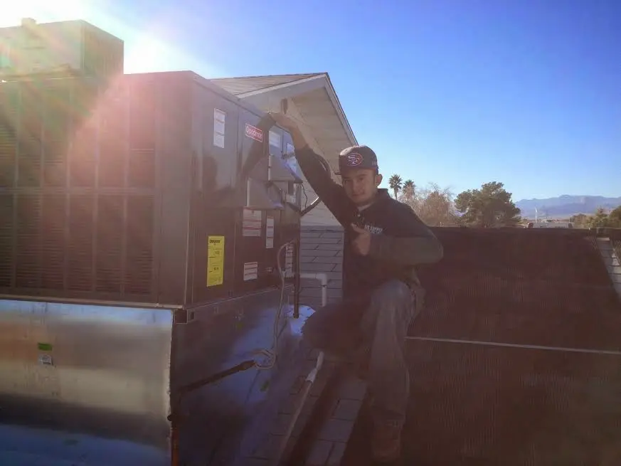 HVAC technician performing Air Duct Repair on a rooftop unit in West Hartford